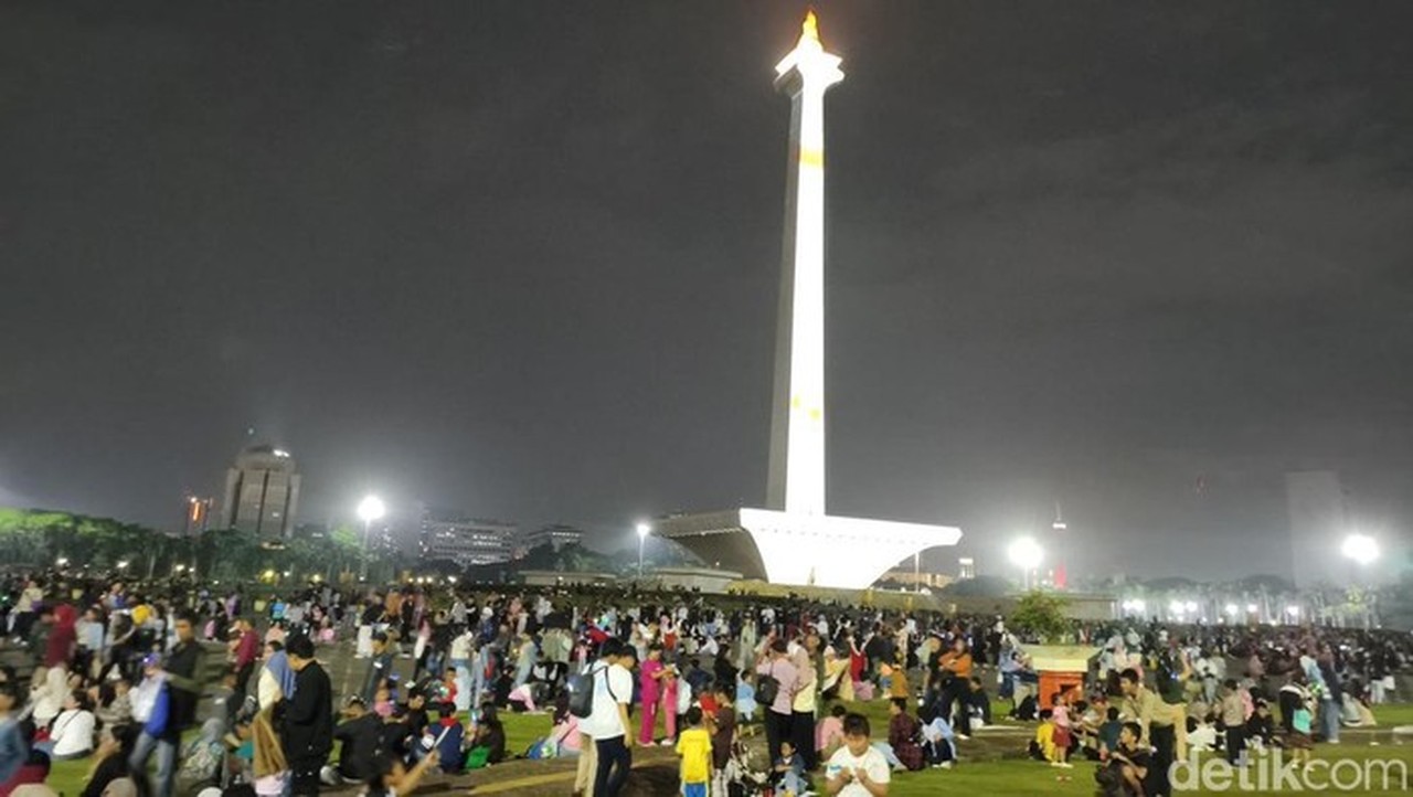 Jakarta Diguyur Hujan Malam Ini. Warga Tetap Ramai Menanti Malam Pergantian Tahun Di Kawasan Monumen Nasional (monas) (kurniawan/detikcom)