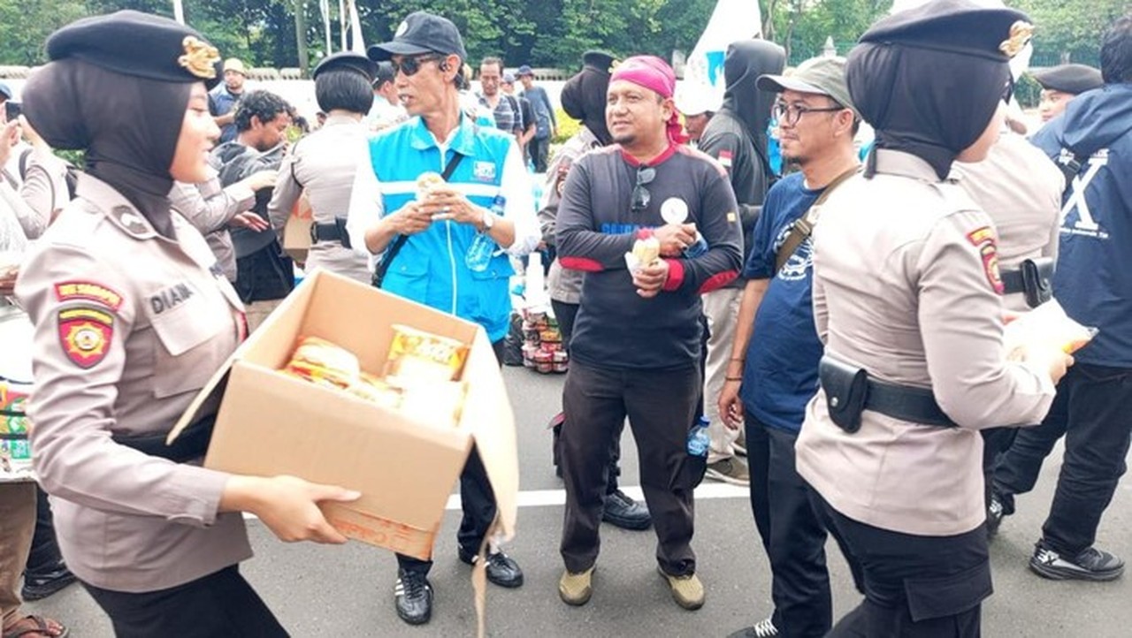 Polwan Polda Metro Membagikan Roti Hingga Air Mineral Untuk Massa Buruh. (foto: Dok. Istimewa)